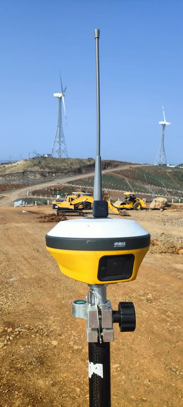 A GNSS receiver on a survey pole near a wind-turbine site