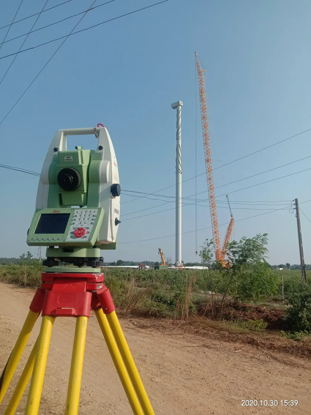 A total station on its tripod at a wind-turbine site